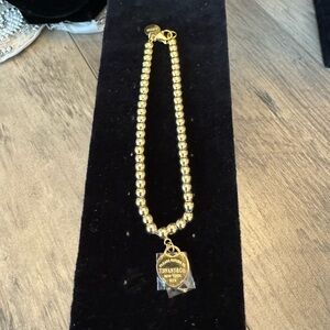 Brand new never worn gold bracelet with charm